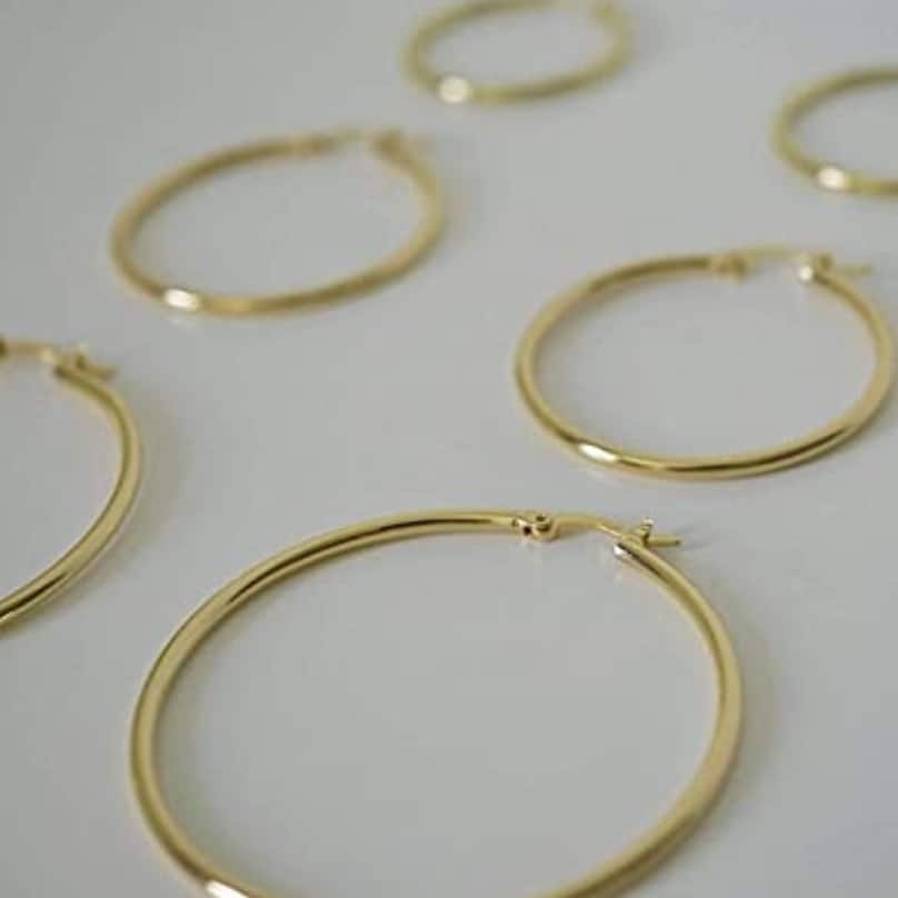 Why gold hoop earrings are a classic accessory worth investing in * gold hoop earrings on grey surface