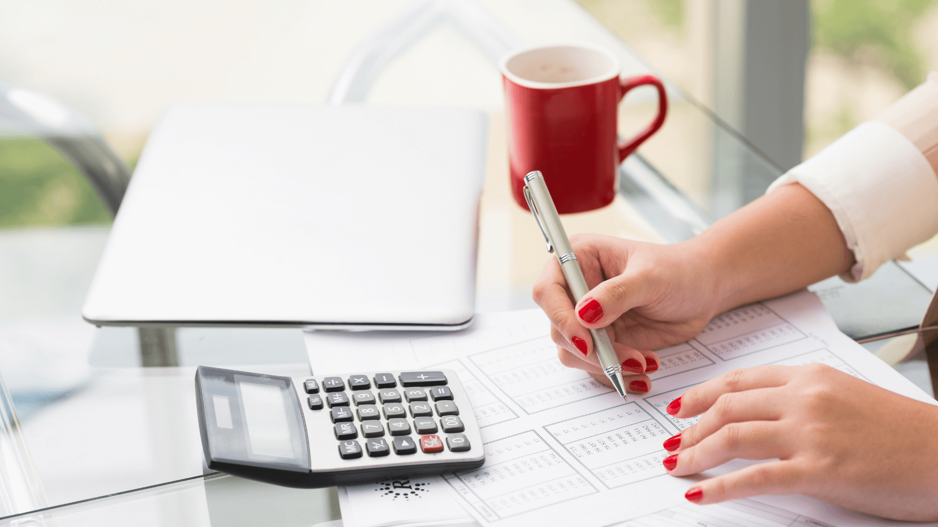 3 Benefits of Hiring a Bookkeeper * Hiring a bookkeeper - calculator, pen and red fingernails