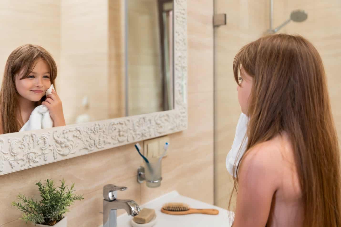 Clean bathroom decor on a budget with 4 easy upgrades * Clean bathroom decor - girl in front of mirror using Soji towel